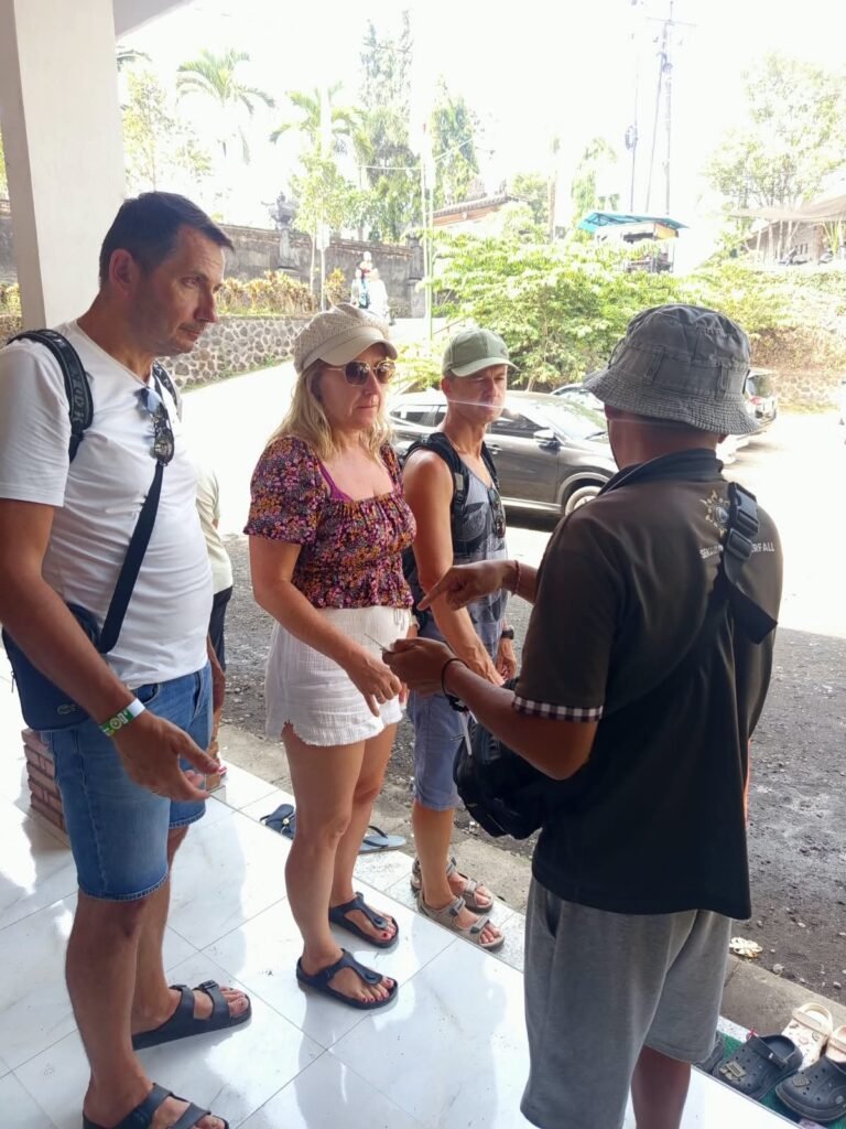 Tourist listening to a local guide explain the Sekumpul Waterfall trekking route in Bali